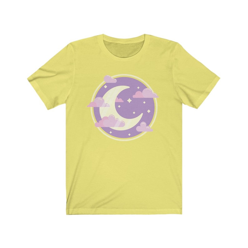May include: A yellow short-sleeved t-shirt with a purple and pink crescent moon and clouds graphic.
