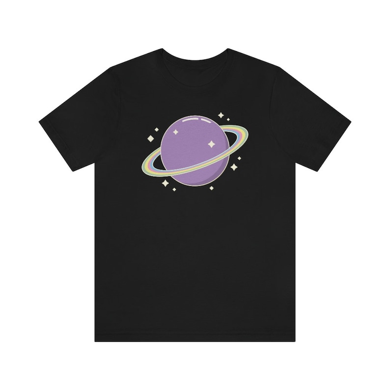 K&ouml;nnte beinhalten: Ein schwarzes T-Shirt mit einem lila Planeten mit einem Regenbogenring darum. Der Planet ist von kleinen wei&szlig;en Sternen umgeben.