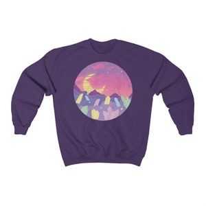 May include: Purple sweatshirt with a graphic of a crescent moon, mountains, and crystals against a pink and purple sunset.