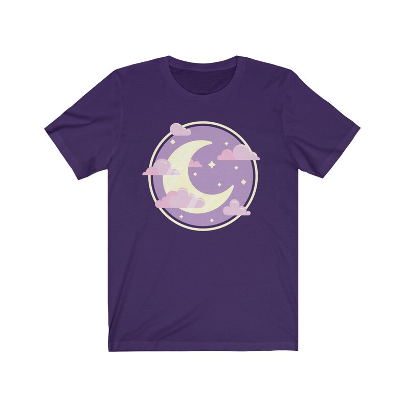 May include: Purple short-sleeved t-shirt with a graphic of a crescent moon in a circle with pink clouds and stars.