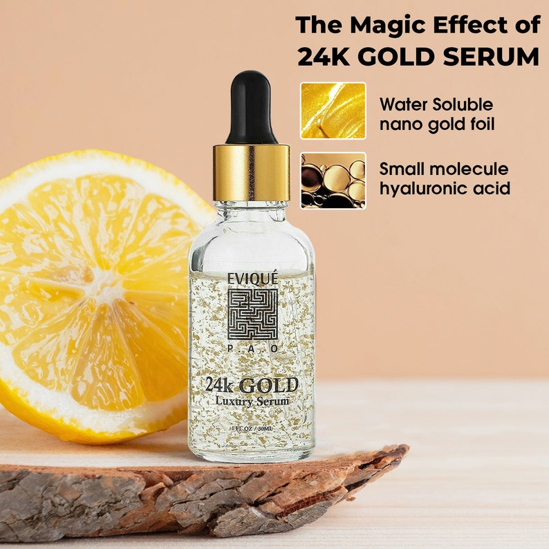 May include: A clear glass bottle with a gold cap and label. The bottle contains a gold liquid with gold flakes. The label reads "EVIQU&Eacute; 24k GOLD Luxury Serum 1 fl oz / 30ml". The bottle is sitting on a wooden surface. The image also includes text that reads "The Magic Effect of 24K GOLD SERUM Water Soluble nano gold foil Small molecule hyaluronic acid".