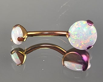 May include: A gold and purple barbell with two opal gems. The gems are round and have a white iridescent finish.