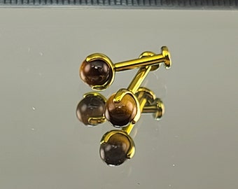 May include: A pair of gold-toned cufflinks with brown tiger's eye stone accents.