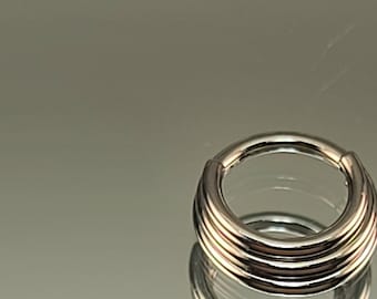 May include: A silver, multi-layered, seamless ring for body piercing.