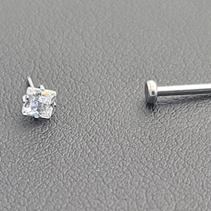 May include: A silver nose stud with a clear square gem and a separate silver post.