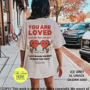 K&ouml;nnte beinhalten: Wei&szlig;es T-Shirt mit einem roten Herz-Motiv und dem Text "You are Loved (just the way you are)". Das Shirt hat au&szlig;erdem den Text "Just in case you need to hear this today" und "Romans 8:28". Das Shirt ist in Eisgrau, XL Unisex, Gildan 5000 erh&auml;ltlich.