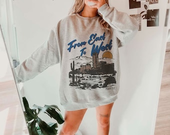 May include: Gray sweatshirt with a graphic print of a cityscape and the text "From East To West" and "Psalm 113:3".
