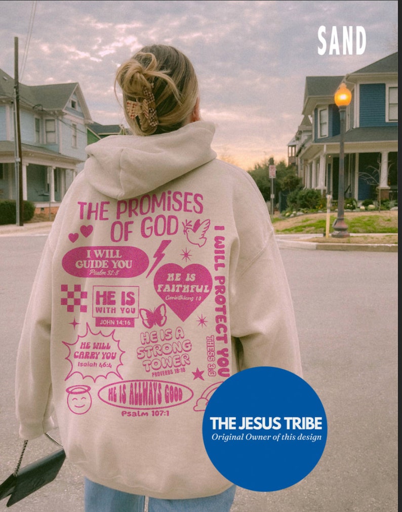 May include: Sand-colored hoodie with pink text and graphics. The back of the hoodie features the text "THE PROMISES OF GOD" and various Bible verses. The design includes hearts, a dove, a butterfly, and other decorative elements. The brand logo "THE JESUS TRIBE" is at the bottom.