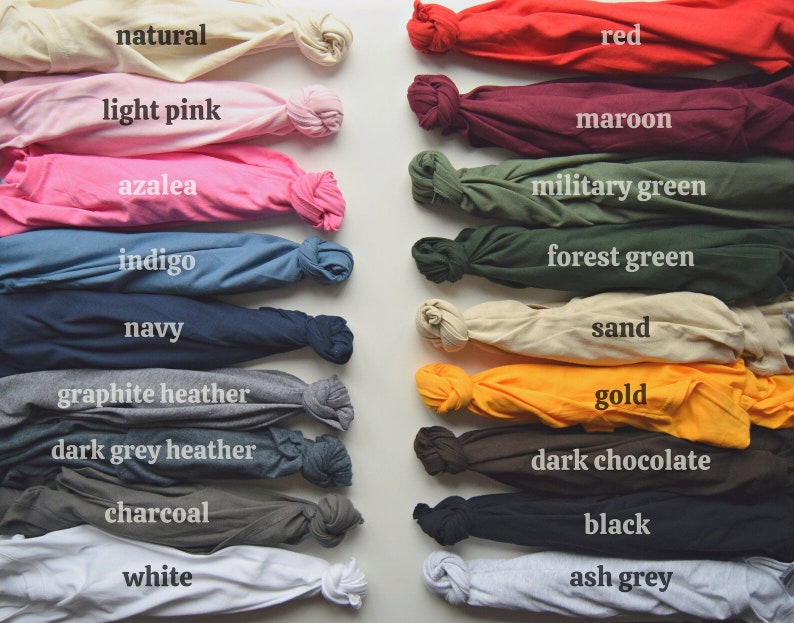 May include: A collection of folded t-shirts in various colors, including natural, light pink, azalea, indigo, navy, graphite heather, dark grey heather, charcoal, white, red, maroon, military green, forest green, sand, gold, dark chocolate, black, and ash grey.