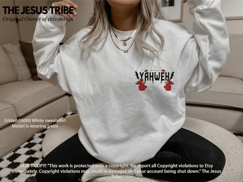 May include: White sweatshirt featuring the text "YAHWEH" in black with red roses on either side. The text is in a bold, gothic font. The sweatshirt is a Gildan 18000 and the model is wearing a size L.