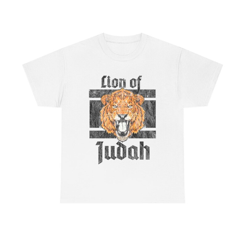 May include: White t-shirt featuring a distressed graphic of a roaring lion with the text "Lion of Judah" in a bold, vintage font. The lion is depicted in shades of orange and brown, set against a black and white rectangular frame.