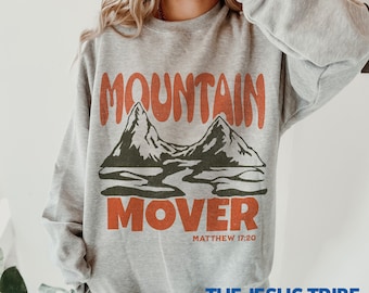 May include: Gray sweatshirt with a red and black graphic design of mountains and the text "Mountain Mover" with the scripture reference "Matthew 17:20".