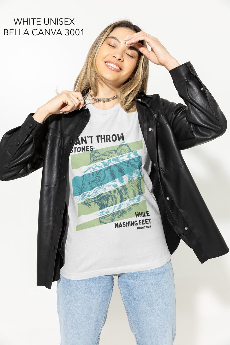 May include: White unisex t-shirt with a graphic print of a tiger's face and the text "Can't Throw Stones While Washing Feet John 13:14".