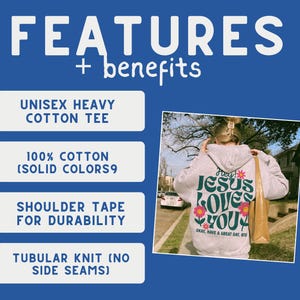 K&ouml;nnte beinhalten: Ein graues Unisex-Heavy-Baumwoll-T-Shirt mit einem Grafikdruck, der "Hey! Jesus Loves You" in gr&uuml;ner und rosa Schrift mit einem Blumendesign sagt. Das Shirt hat Schulterband f&uuml;r Haltbarkeit und ist aus 100% Baumwolle (einzelne Farben) gefertigt. Das Shirt ist ein Schlauchgewebe ohne Seitenn&auml;hte.