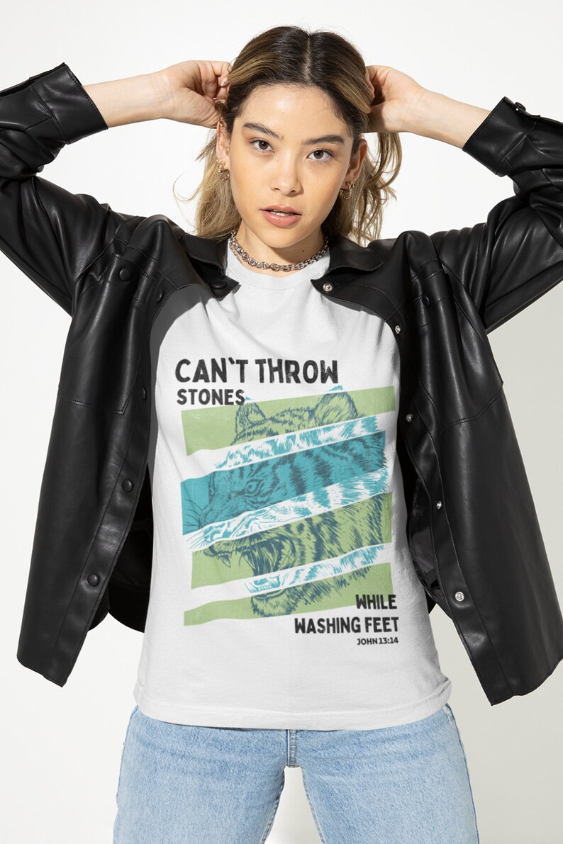 May include: White t-shirt with a graphic print of a tiger's face and the text "Can't Throw Stones While Washing Feet John 13:14".