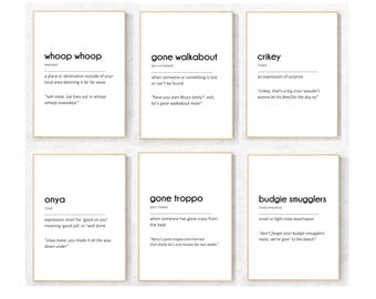 Op de afbeelding: Zes ingelijste kunstdrukken met definities van Australisch jargon. Elke print heeft een witte achtergrond met zwarte tekst. De woorden zijn onder meer "whoop whoop", "gone walkabout", "crikey", "onya", "gone troppo" en "budgie smugglers".