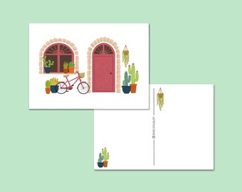 Fröhliche Kartenfassade mit Pflanzen, Kakteen, Fahrrad und einer rosa Tür
