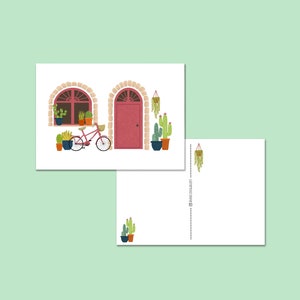 Fröhliche Kartenfassade mit Pflanzen, Kakteen, Fahrrad und einer rosa Tür