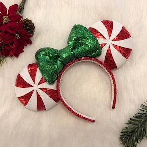May include: Red and white peppermint candy cane inspired Minnie Mouse ears with a green sequin bow.