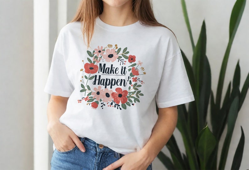 May include: White t-shirt with a floral design and the text "Make it Happen'" printed on the front.