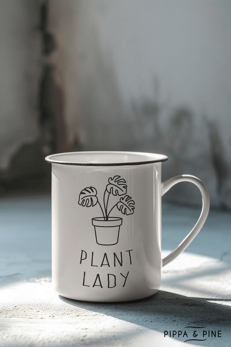 May include: White enamel mug with a black outline of a potted plant and the text "Plant Lady".