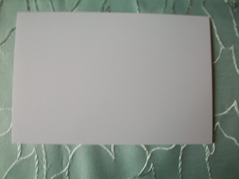 May include: A blank white card, suitable for writing or drawing on.