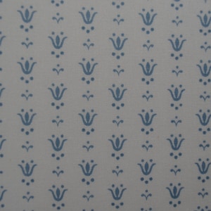 May include: A repeating pattern of blue floral motifs on a light gray background. The design features stylized tulip-like shapes with small dots and curved lines, creating a symmetrical and decorative pattern. The fabric appears to have a subtle texture.
