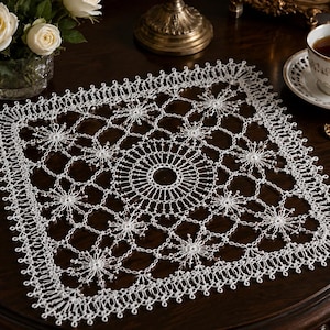 Può includere: Un centrino quadrato in pizzo bianco caratterizzato da un intricato motivo circolare centrale circondato da motivi ripetuti a forma di stella. Il delicato lavoro mostra una complessa rete di anelli interconnessi e un bordo smerlato.