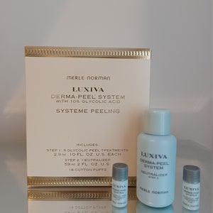 May include: A white box with gold trim and the text "Merle Norman Luxiva Derma-Peel System with 10% Glycolic Acid Systeme Peeling" on the front. The box contains a set of skin care products, including a bottle of neutralizer and two smaller bottles of glycolic peel treatment. The bottles are labeled "Luxiva Derma-Peel System" and "Merle Norman".