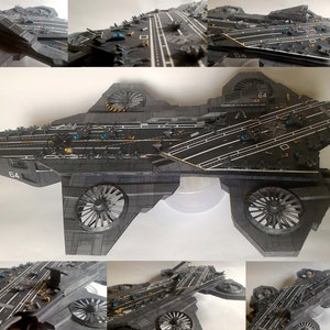 Könnte beinhalten: Detailliertes Modell eines grauen Flugzeugträgers mit weißen Landebahnmarkierungen und Miniaturflugzeugen. Das Modell verfügt über große Turbinentriebwerke und die Nummer "64" an der Seite. Das Design ist aufwendig und realistisch.