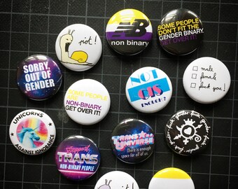 9 “NON BINARY | ENBY“ pins of your choice.