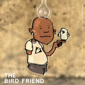 Könnte beinhalten: Eine Comicfigur mit brauner Haut und einem weißen Hemd hält einen kleinen weißen Vogel. Die Figur trägt ein weißes Hemd mit einem kleinen Vogelmotiv auf der Vorderseite. Der Text "THE BIRD FRIEND" ist unter dem Bild gedruckt.