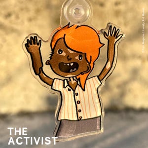 Op de afbeelding: Een cartoonillustratie van een persoon met oranje haar en vitiligo die een gestreept shirt en een grijze broek draagt. De persoon steekt beide armen in de lucht. De tekst "THE ACTIVIST" staat onder de afbeelding.