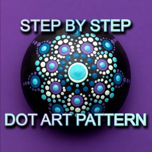 May include: A black round rock with a white, blue, and purple dot art pattern. The rock has a mandala design with a six-pointed star in the center. The text "STEP BY STEP DOT ART PATTERN" is above the rock.