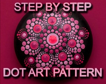 May include: Step-by-step dot art pattern on a black rock. The pattern features pink and red dots arranged in a mandala design.