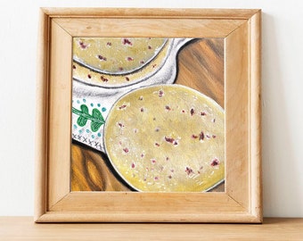 May include: A painting of two yellow and white round cakes with red sprinkles on a wooden table. The cakes are in a white bowl with a green leaf design.