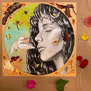 May include: A mixed media artwork featuring a woman's face with closed eyes, surrounded by dried flowers and leaves. A small white bird with a long beak is perched on a branch near the woman's face.