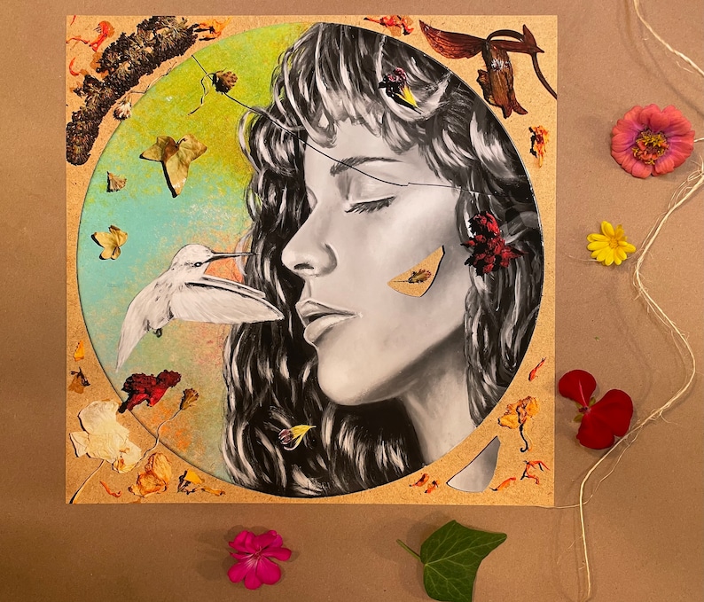 May include: A mixed media artwork featuring a woman's face with closed eyes, surrounded by dried flowers and leaves. A small white bird with a long beak is perched on a branch near the woman's face.
