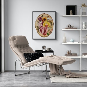 May include: A beige chaise lounge with a black and white polka dot pillow. The chaise lounge is in a living room with a white shelf unit and a framed print of a heart surrounded by flowers on a wood slice.