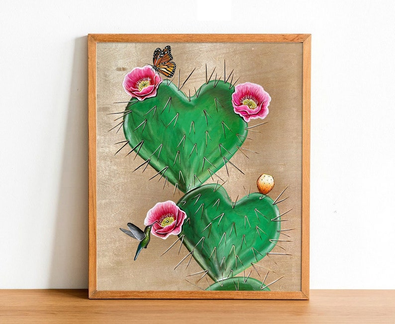 May include: A painting of a heart-shaped cactus with pink flowers and a butterfly. The cactus is green and has spines. The butterfly is orange and black. The background is a light brown.