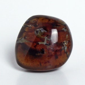 Peut inclure: Une pierre d'agate lisse et polie, de couleur brune et blanche, avec un motif tourbillonnant. La pierre est translucide et a une finition brillante.