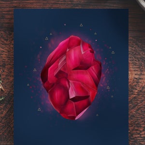 May include: A deep red gemstone with a rough, faceted surface. The gemstone is surrounded by a dark blue background with gold triangles.