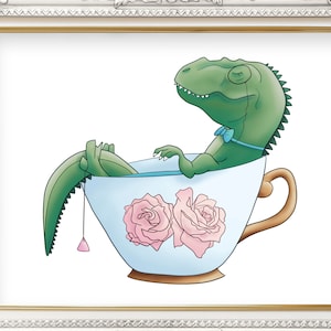 May include: A green dinosaur wearing a blue bow tie sits in a teacup with pink roses on the side. The teacup is white with a blue interior and a gold handle.