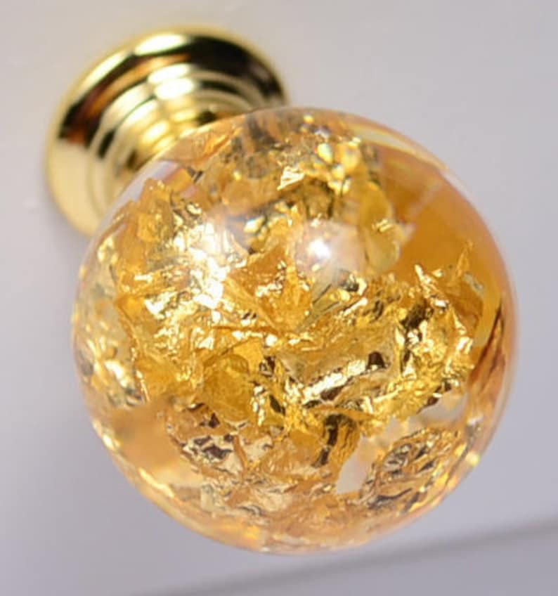May include: A gold-toned cabinet knob with a clear glass sphere filled with gold leaf flakes.