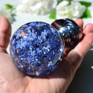 May include: A clear glass sphere filled with tiny blue forget-me-not flowers, attached to a silver knob.