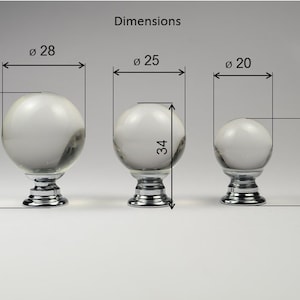 May include: Three clear glass knobs with chrome bases. The knobs are 28, 25, and 20 inches in diameter. The heights are 38, 34, and 29 inches.