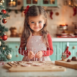 May include: A young girl with long brown hair wears a red and white dress and a red bow in her hair. She is smiling and looking at the camera while holding a small object in her hands. She is standing in a kitchen with a Christmas tree in the background.