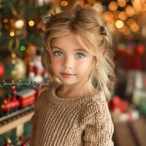Puede incluir: Una niña joven con cabello rubio y ojos azules lleva un suéter de punto marrón. Está de pie frente a un árbol de Navidad con adornos y luces.