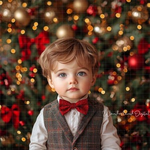 Puede incluir: Un niño pequeño con un chaleco de cuadros y una pajarita roja se encuentra frente a un árbol de Navidad con adornos rojos y dorados. El árbol está decorado con luces.