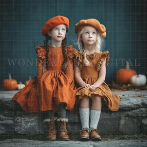 May include: Two young girls wearing matching orange berets and dresses sit on a stone ledge. The dresses have ruffled sleeves and are paired with boots and patterned socks. Pumpkins are in the background. The image has the text "WONDERLAND DIGITAL".